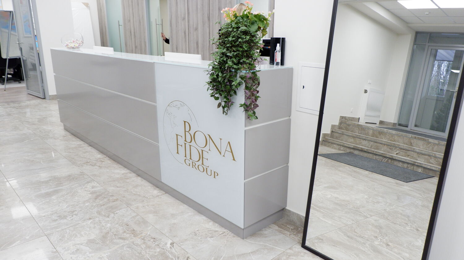 Низ стойки reseption украшен логотипом компании Бона Фиде Групп